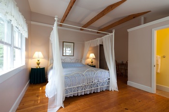 white canopy bed and the wood floor