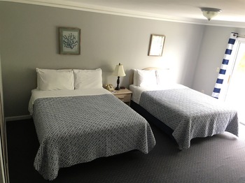 DOUBLE BEDS IN AN INTERIOR OF A MOTEL TYPE ROOM 