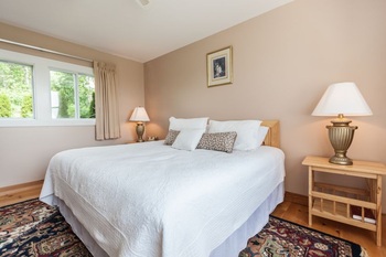 ROOM WITH LARGE BED WHITE LINENS AND LAMP AND NIGHT TABLE